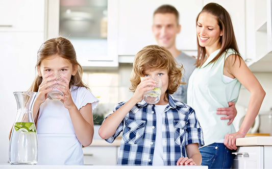 Familie in Küche - Kinder trinken Osmosewasser